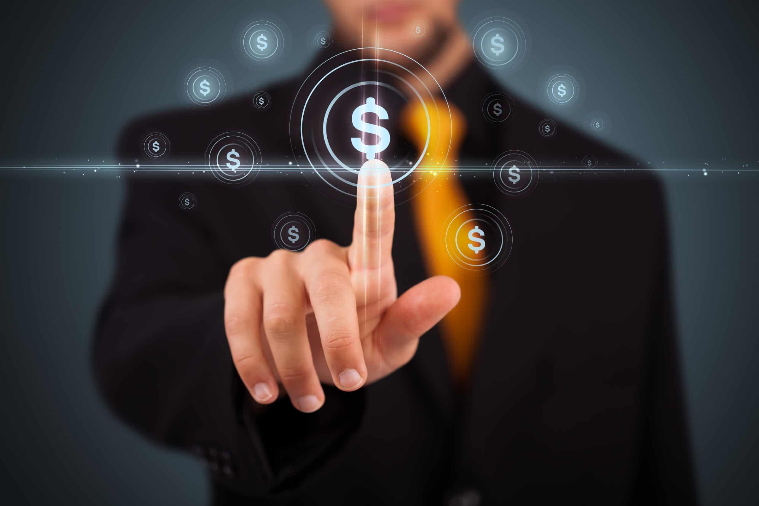 A man in a suit pressing a button that looks like a dollar sign