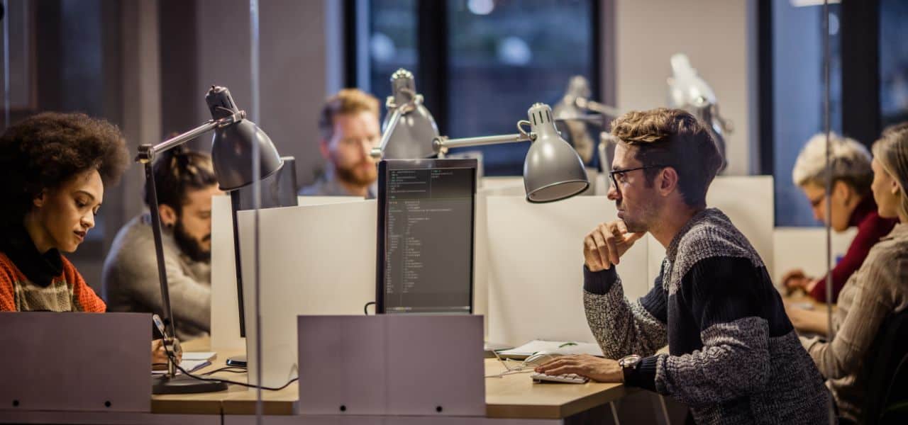 group of people sitting at their desks in an office environment